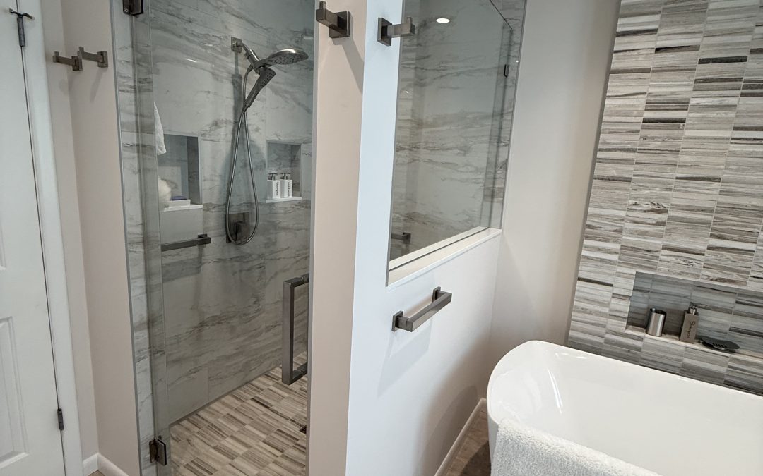 new modern shower enclosure with white wall, glass partitions, and tile next to a soaking tub